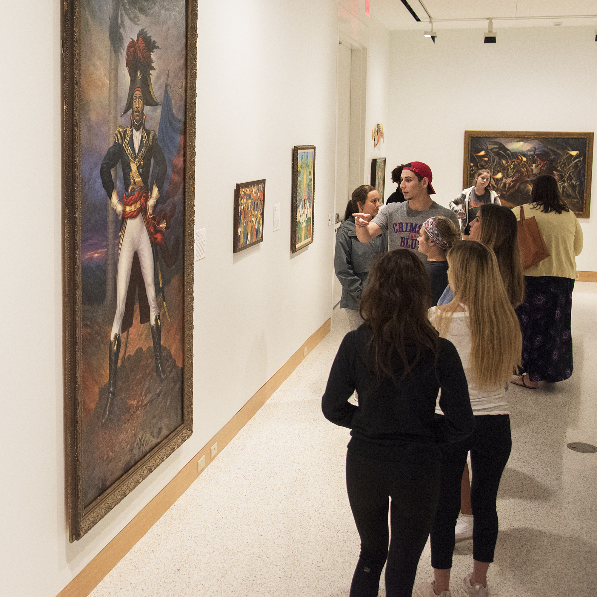 Students looking at paintings in museum